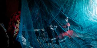A woman and a child sleep under a mosquito net