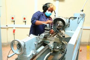 A mechanical engineering student operates a lathe machine at Nyeri National Polytechnic