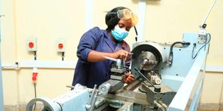 A mechanical engineering student operates a lathe machine at Nyeri National Polytechnic