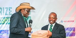 Men winner Tirus Githaiga (right) receives his prize from club chairman Paul Munyao