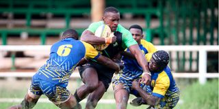 Kabras Sugar's Griffin Chao (centre) charges against Homeboyz Peter Mboya (left) and Godfrey Kile