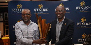 Machakos Golf Club's Charles Kithuku receives the ICEALION King of the course trophy from ICEALION CEO Philip Lopokoiyit 