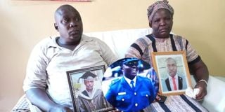 Devastated Dickson Litali and his wife Everline Litali hold portraits of their son Captain Hillary Litali