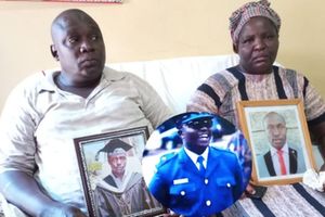 Devastated Dickson Litali and his wife Everline Litali hold portraits of their son Captain Hillary Litali