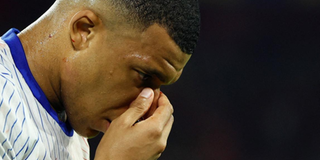 Kylian Mbappe holds his face 