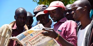 Youth read the Daily Nation newspaper.