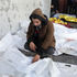 A person mourns near the bodies of Palestinians killed in Israeli strikes