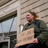woman holds a placard outside the USAID building