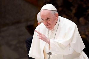 Pope Francis waves to pilgimsat Paul-VI hall in The Vatican.