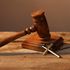 Judge's gavel and cross on wooden table