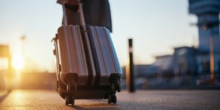 Close up of traveler with a suitcase at the airport