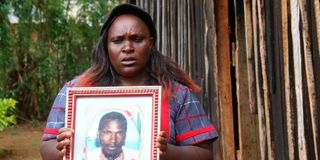 Lucy Makena holding a photograph of her late husband at Mia Moja Village in Laikipia County. 