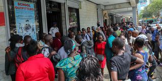 Parents, and guardians queue outside the School Outfitters 