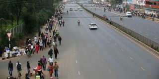 Nairobians walk along Thika Road as they head to the city centre