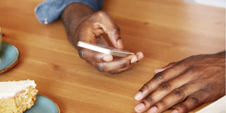 Close up shot of African man's hands holding mobile phone