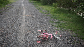 Children's bikecycle and shoe on stone road. missing children concept.