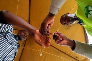 An IEBC official inks thr finger of an inmate at Kamiti Maximum Prison