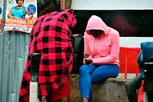 Residents sit at a corner all covered up to keep warm 