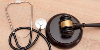 A gavel and stethoscope on wooden background