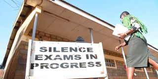 A KCSE invigilator enters an exam hall at Uasin Gishu High School